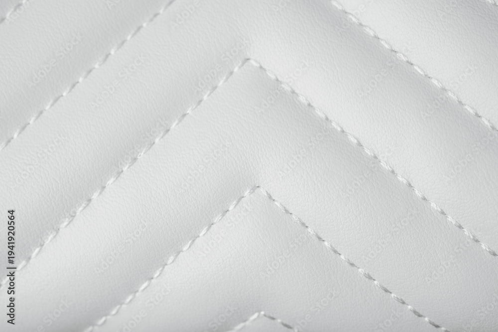 Fototapeta premium Elegant white quilted leather texture with neat chevron stitching creating a beautiful abstract pattern