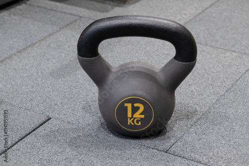 Kettlebell weights placed on the gym floor for strength training and exercise sessions during workout routines