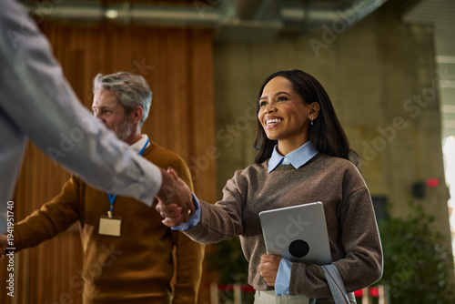 Foto Diverse businesswoman shaking hands with colleague at a friendly professional co