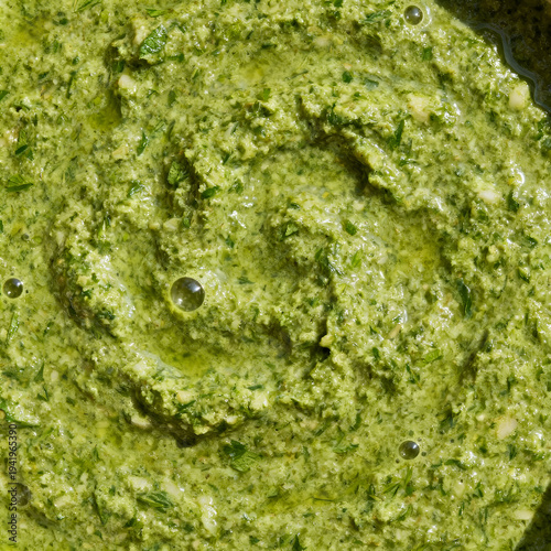 Macro close up of fresh green herb sauce texture with olive oil and mint leaf