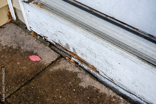 Rotting Wooden Trim Near Ground Level, Wood Rot and Moisture Damage on House Exterior