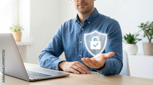 Man protecting data with shield icon at modern desk
