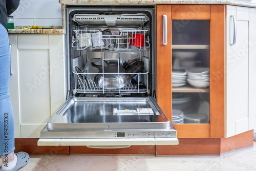 Open dishwasher with clean dishes in a modern kitchen