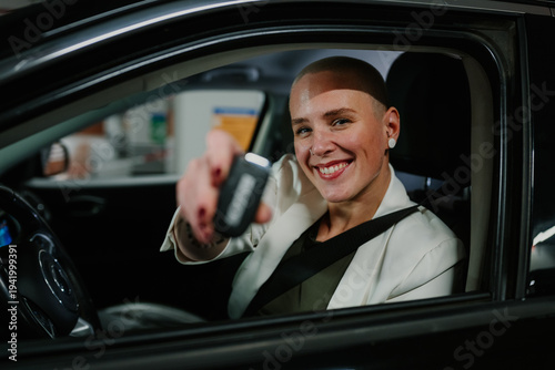 Tableau sur toile Happy woman driver receiving new car key, celebrating vehicle ownership and feel