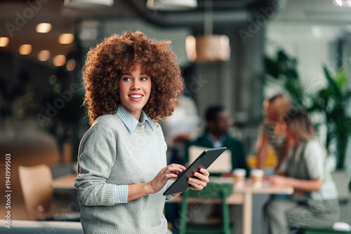 Young businesswoman smiling using tablet in office