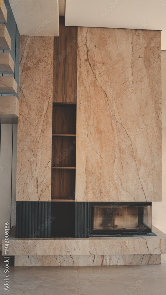 Obraz premium Modern fireplace with marble and wood accents, featuring built-in shelving and a sleek glass-fronted firebox