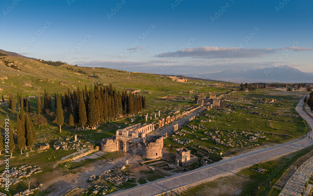 Obraz premium Aerial drone view of Hierapolis Antik Kenti and the famous Pamukkale travertines in Denizli, Turkey, showing ancient ruins, Roman theater, columns, and scenic landscape from above.