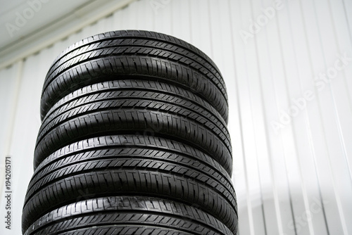 A vertical stack of new car tires