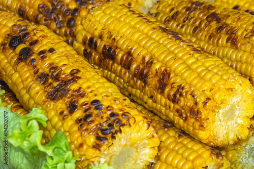 Schilderij op canvas Grilled corn on the cob with charred kernels served on barbecue platter with fre