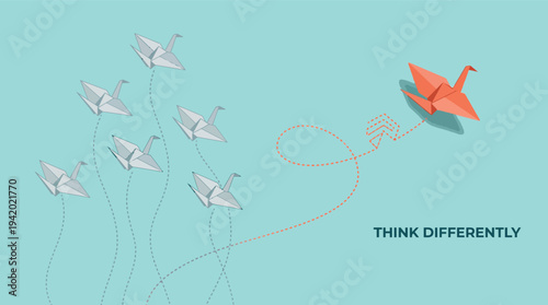 Innovation and leadership concept showing a unique orange origami crane flying on a different path away from a flock of grey birds on a blue background.