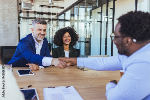 Business Meeting Handshake Sealing Agreement Between Diverse Colleagues In Modern Office Conference Room