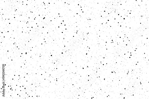 A collection of small black dots scattered randomly across a bright white canvas