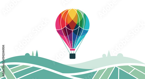 Giant colorful hot air balloon with geometric patterns flies high above rolling green hills in a modern graphic art.