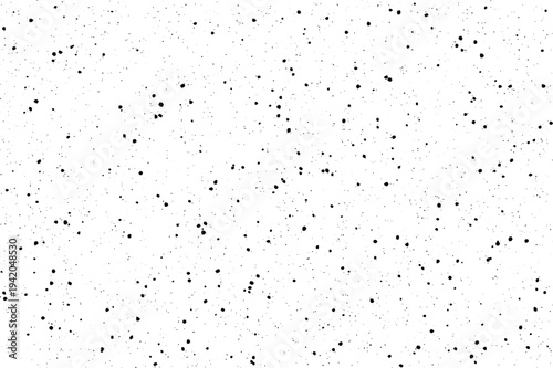 A scattered pattern of numerous small black irregular dots creating a distressed look on a pristine white surface