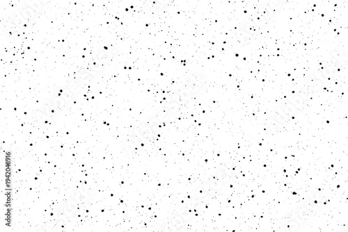 A simple clean white surface covered with small dark paint splatters and fine grain