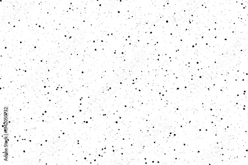 A stark visual with countless tiny black flecks creating a scattered effect on a pristine white backdrop