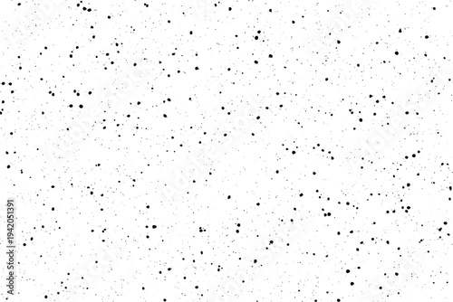 A wide variety of small dark particles are scattered randomly across an empty white background