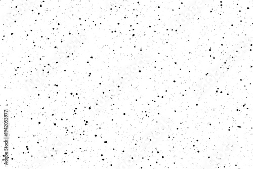 Countless tiny irregular black points create a distinctive scattered grainy overlay on a white surface