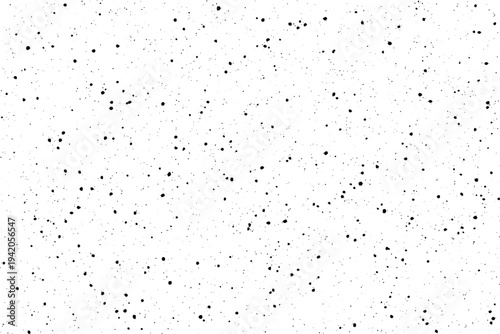 Numerous small black specks are sparsely distributed across a crisp white backdrop