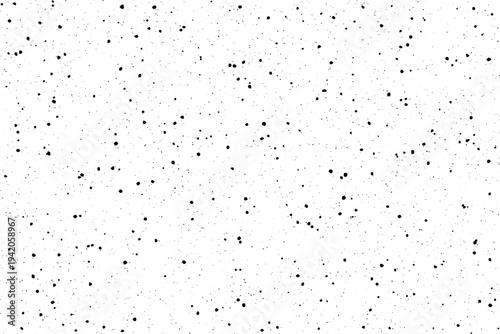 Scattered black ink splatters create a distressed grain texture on a bright white surface