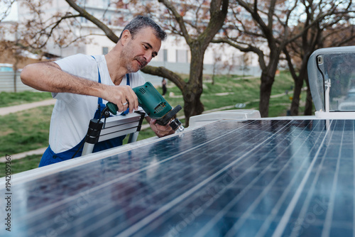 Professional installer using tools to install a solar panel on the roof of a camper van.
Worker installing a solar panel on a camper van.
Renewable energy, a self-sufficient and sustainable energy s