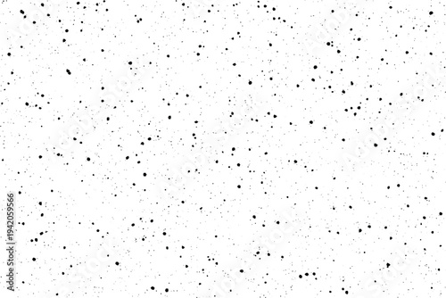 Scattered tiny black dots create an irregular textured pattern on a clean white surface