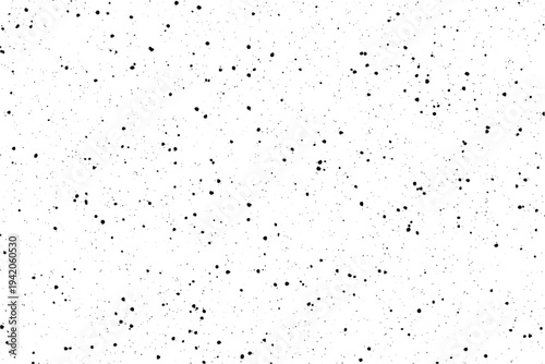Small black specks cover a pristine white plane, creating a visually interesting speckled surface
