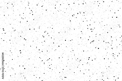Small irregular black particles spread across a bright white surface forming a distressed texture