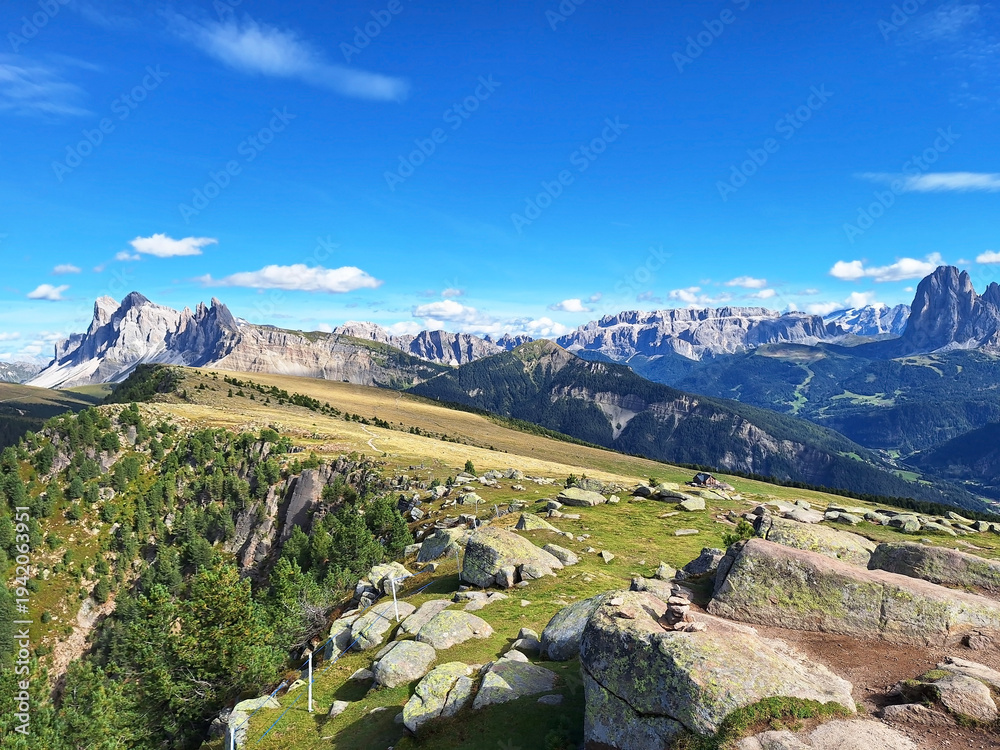 Fototapeta premium Mountain landscape from Resciesa Dedora towards Mount seceda and Mount Pic against a blue summer background.