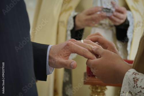Detail of the bride and groom at their wedding ceremony, elegantly dressed in the church