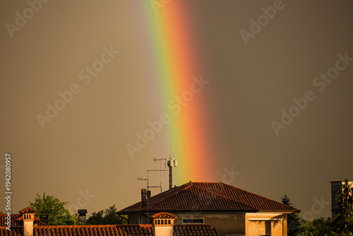 Wallpaper Mural Rainbow in sky clouds over Vibrant Vertical Rainbow Over European Rooftops at Golden Hour village houses Torontodigital.ca