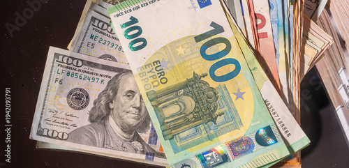 High-value global currencies close-up featuring US dollar and euro banknotes stacked together, symbolizing international finance, foreign exchange, banking, wealth, investment and global economy.