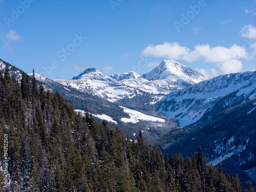 Snow-Covered Mountain Peaks And Pine Forest Valley In British Columbia, Canada On A Clear Winter Day