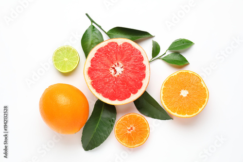 Different fresh citrus fruits and green leaves on white background, flat lay