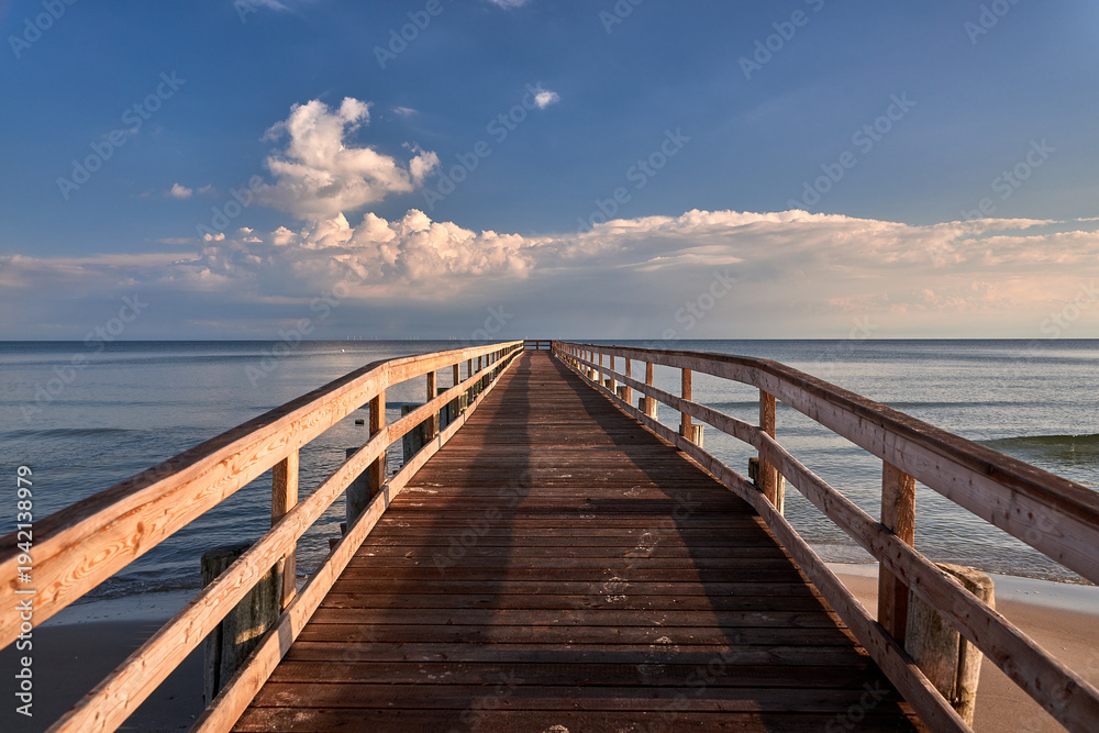 Fototapeta premium Scenic Wooden Pier at Zingst Beach Over Baltic Sea at Sunset