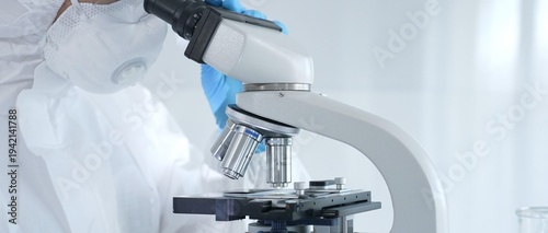 Konstfotografi Medical virologist in a hazmat suit, mask, and gloves, diligently working at a microscope in a laboratory researching viruses