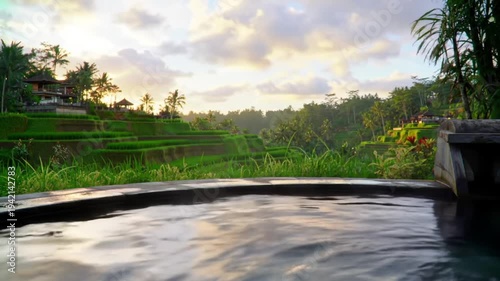 Peaceful infinity pool overlooks lush green rice terraces at sunrise.