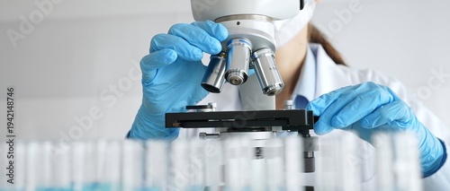 Fotografie Laboratory scientist wearing blue protective gloves carefully positioning microscope slide, demonstrating research precision