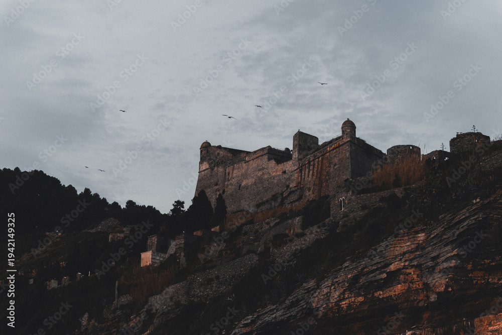 Fototapeta premium time Dramatic Medieval Castle on Cliff at Dusk, Cinque Terre Italy