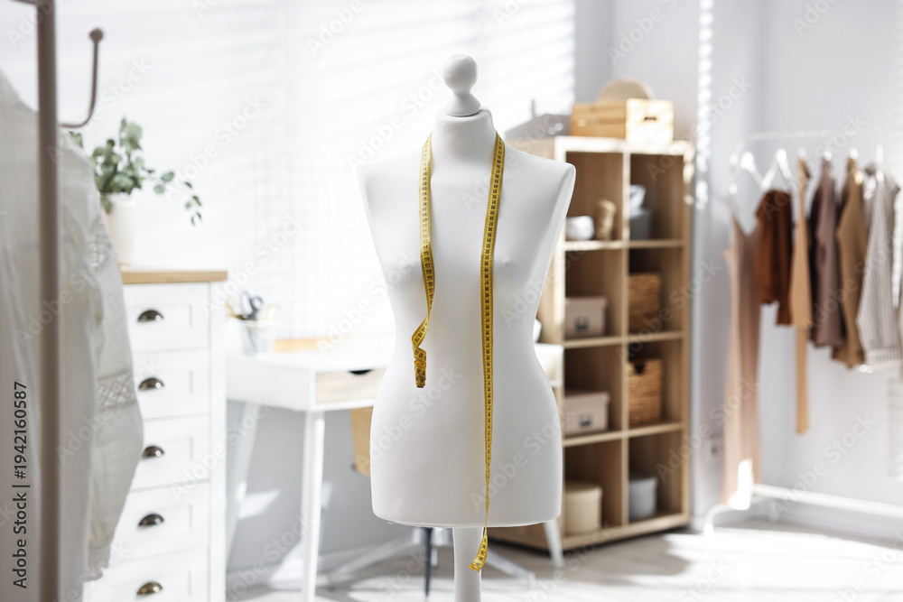 Fototapeta premium Female mannequin with measuring tape in workshop