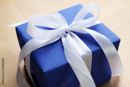 Obraz na płótnie Beautiful gift box with bow on wooden table, closeup