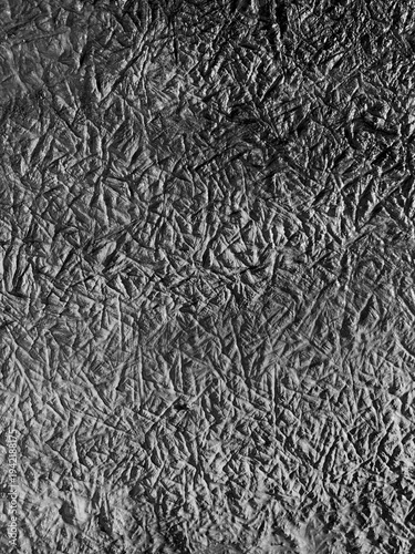 Abstract frozen texture with chaotic ice crystal patterns forming a natural winter background. Close-up of frost structures on a cold surface creating a monochrome organic texture with intricate lines