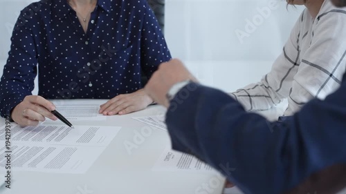 Corporate professionals analyzing contract details, gesturing toward key points while negotiating partnership terms in modern office boardroom