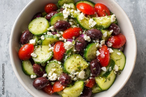 This bowl shows a fresh cucumber tomato olive feta salad.