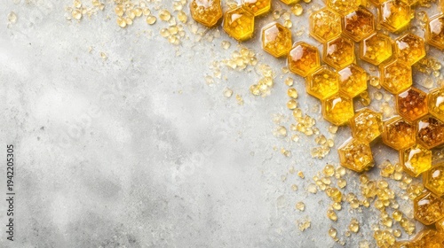 Golden honeycomb with scattered honey droplets on concrete surface