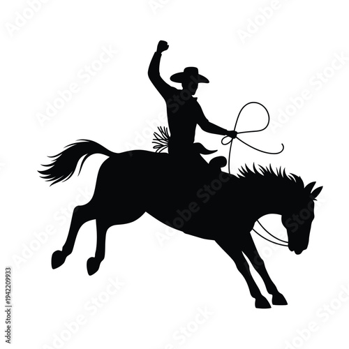 Silhouette of a cowboy skillfully roping while riding a rearing horse