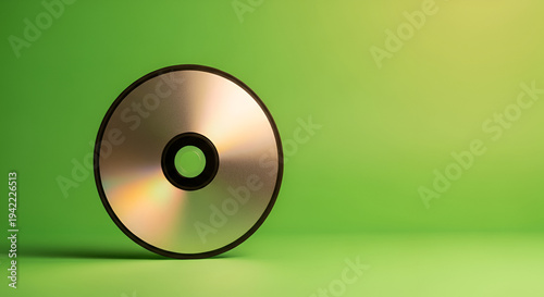Shiny Compact Disc Reflecting Light Against a Vibrant Gradient Green Background With Subtle Yellow Spotlight