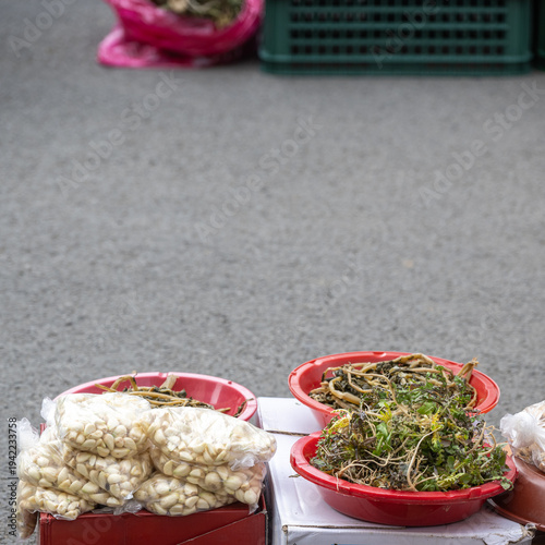 Quadro em tela Fresh shepherd's purse and peeled garlic cloves at a traditional market