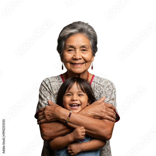 Smiling Indigenous grandmother hugging her laughing young grandson, intergenerational bond