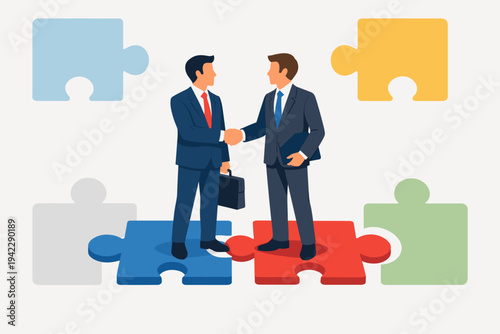 Two professional businessmen in suits shaking hands while standing on connecting jigsaw puzzle pieces, representing successful partnership, corporate merger, teamwork, and business solution.
